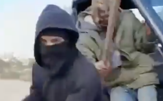 Two masked assailant wielding clubs approach an off-camera Israeli human rights activist in Qusra, in the northern West Bank, February 27, 2026. (Screen capture: X/Looking the Occupation in the Eyes)